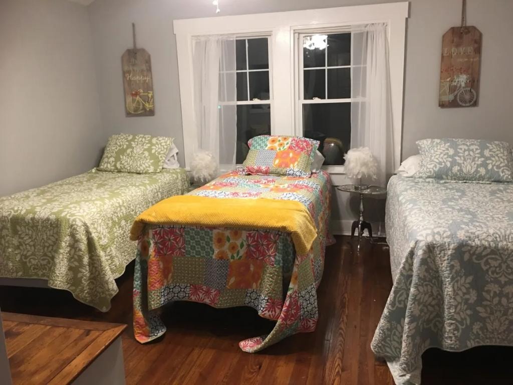 Bedroom with three beds and colorful quilts