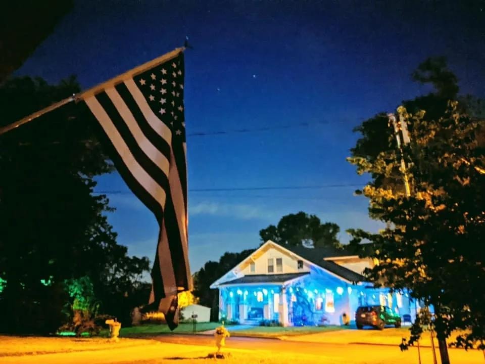 American flag and Hinkle Hill Inn illuminated at night